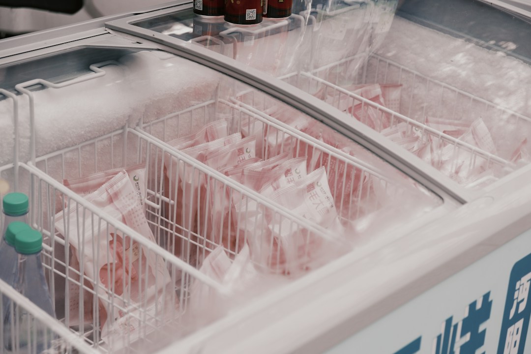 Freezer comercial coberto de gelo com carnes embaladas