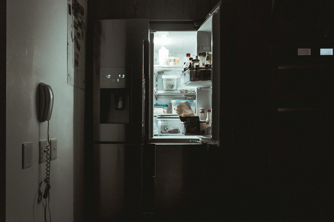 Geladeira aberta em cozinha escura
